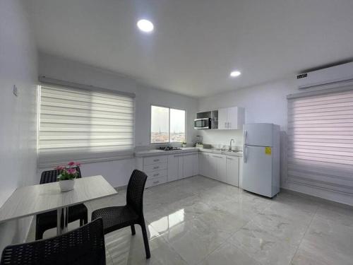 a kitchen with a table and a white refrigerator at Apto #18 con Hermosa Vista piso 3 in Machala