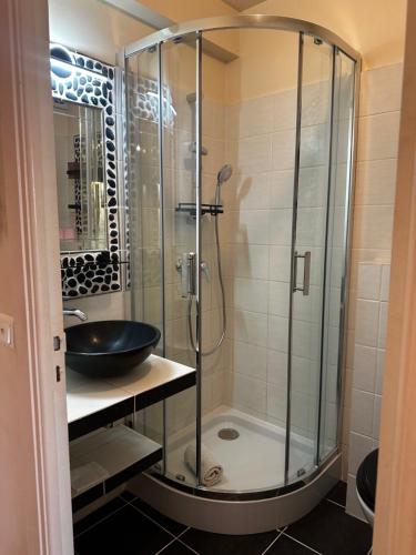 une salle de bain avec une douche en verre et un lavabo dans l'établissement CHARMANT STUDIO AVEC PISCINE à LA MIRANDOLE, à Vallauris