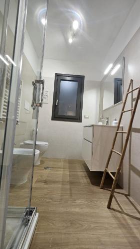 a bathroom with a sink and a toilet and a mirror at The Stopover Suite House 2 in Fiumicino