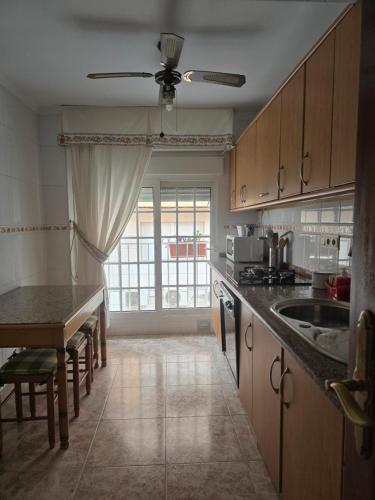 a kitchen with a sink and a table and a window at apartamento alma in Almería