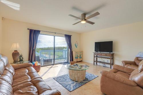 a living room with leather couches and a television at Oceanside Beachfront Fort Pierce Retreat in Fort Pierce