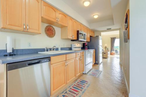 a kitchen with wooden cabinets and a dishwasher at Oceanside Beachfront Fort Pierce Retreat in Fort Pierce