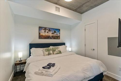Un dormitorio con una cama blanca con dos toallas encima. en Downtown Lux Bldg - Rooftop Pool-hottub - King bed, en Salt Lake City