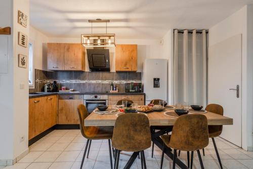 une cuisine avec une table et des chaises en bois dans l'établissement Phantasia by Kleidos, 10 min de Disney! Jolie Maison Familiale 6P, 2 chambres, Terrasse, Parking, à Magny-le-Hongre