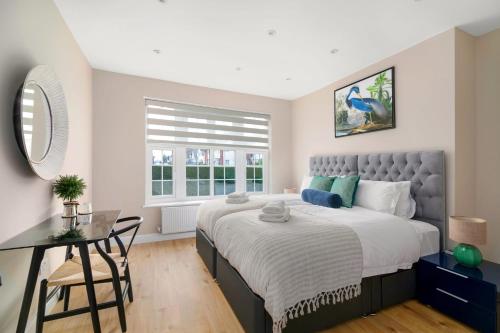 a bedroom with a large bed with a desk and a window at The golden place in London