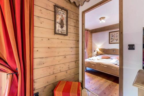 une chambre avec un lit et un miroir dans l'établissement Les Chalets Du Gypse - LES CHALETS DU GYPSE A04 MAE-3861, à Saint-Martin-de-Belleville