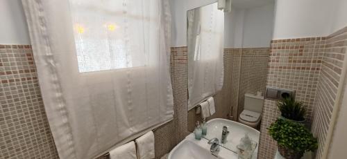 a bathroom with a sink and a toilet and a window at LUXURY VILLA ZAGARA GOLF & Pool in Estepona