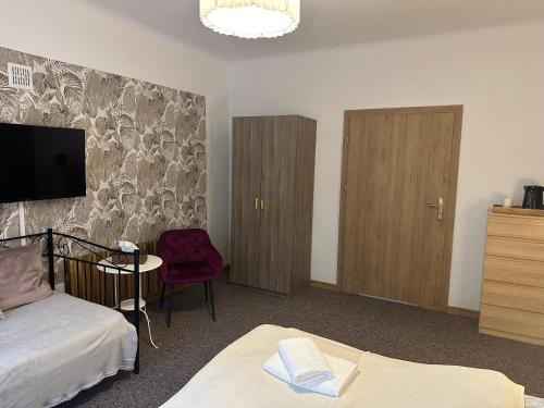 a hotel room with two beds and a tv at Pensjonat Galicja in Józefów