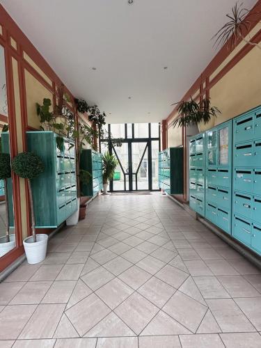 un couloir avec des casiers verts et des plantes en pot dans un bâtiment dans l'établissement Charmant Studio avec Balcon, à Paris