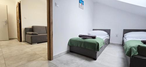 a room with two beds and a chair and a mirror at WODA I WIATR PL Wiatrakowa 26 Jastrzębia Góra in Jastrzębia Góra