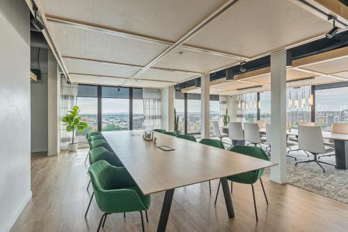 a conference room with a long table and green chairs at Central Studio Apt - 65 TV - Gym - Parking in Salt Lake City