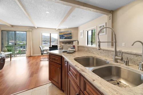 een keuken met een grote wastafel en een woonkamer bij Lakeview Condo - Lakefront Complex, Lake Views, Heated Pool in Big Bear Lake