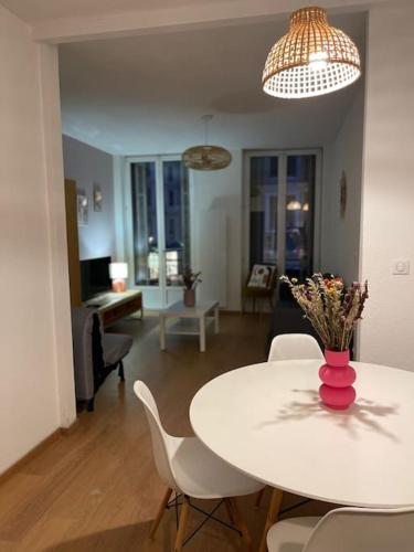 un salon avec une table et des chaises blanches dans l'établissement Mulhouse hyper centre - Grand T3- Aux bons enfants, à Mulhouse