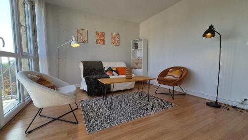 un salon avec un canapé, une table et des chaises dans l'établissement Appartement Clara Parking Gratuit, à Mont-Saint-Aignan