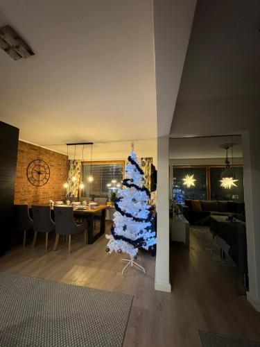 a christmas tree in the middle of a living room at Lapland Cozy Apartment in Rovaniemi