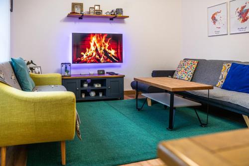 a living room with a couch and a fireplace at Large bedroom, close to Airport and City Centre in Edinburgh
