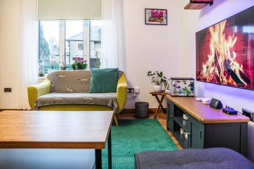 a living room with a couch and a tv at Large bedroom, close to Airport and City Centre in Edinburgh