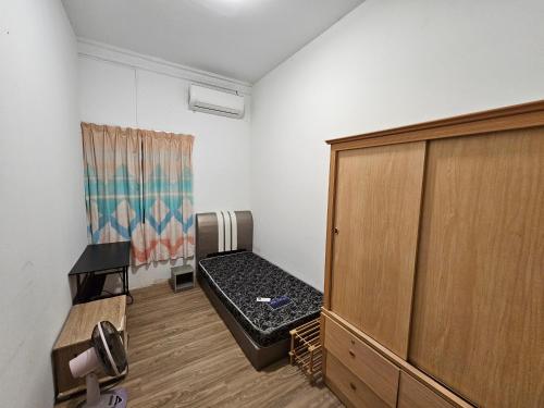 a room with a bed and a wooden cabinet at Amoy Lane Hostel Penang in George Town