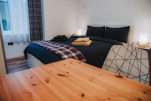 ein Schlafzimmer mit einem Bett und einem Holztisch in der Unterkunft Large bedroom, close to Airport and City Centre in Edinburgh