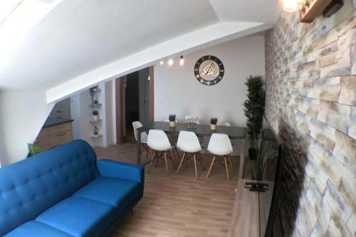 un salon avec un canapé bleu et une table dans l'établissement Sous les toits-Hypercentre-Pas de Frais de Ménage, à Mulhouse