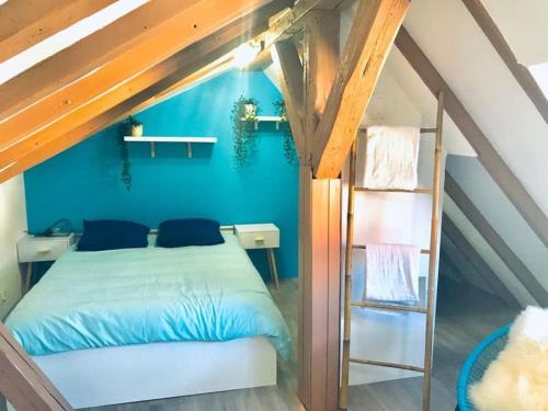 une chambre avec un lit et un mur bleu dans l'établissement Sous les toits-Hypercentre-Pas de Frais de Ménage, à Mulhouse