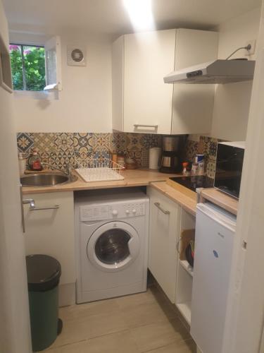 une cuisine avec une machine à laver et un évier dans l'établissement Studio Sarcelles Village, à Sarcelles