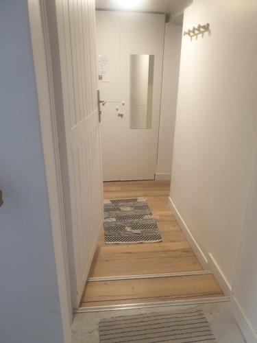 un couloir avec une porte menant à une salle de bains. dans l'établissement Studio Sarcelles Village, à Sarcelles
