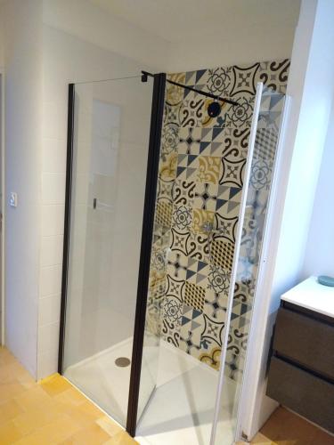 une douche avec une porte vitrée dans une salle de bain dans l'établissement Grande maison, calme, proche de la mer, à Camoël
