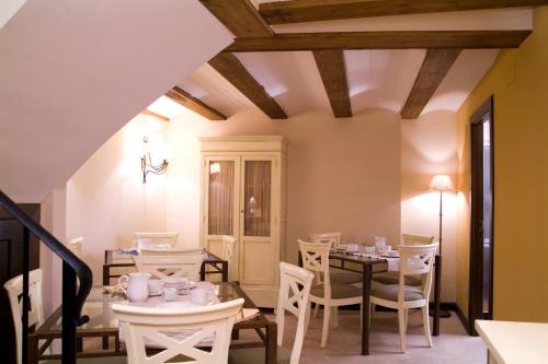 uma sala de jantar com cadeiras e mesas brancas e um tecto em La Casa del tío Americano em Albarracín