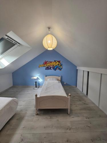 a bedroom with a bed and a blue wall at Grande maison proche de Chambord et de la Loire in Saint Laurent Nouan