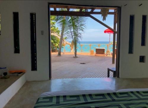 a bedroom with a door open to a view of the ocean at Isla Única- Islas del Rosario in Isla Grande
