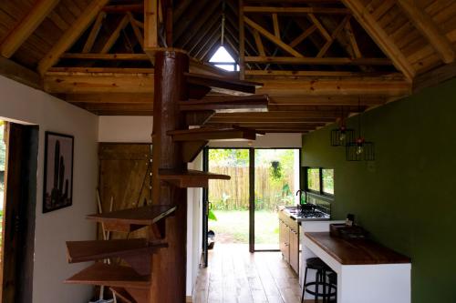 a kitchen with green walls and wooden beams at RíoBosque Cabañas de lujo frente al rio desayuno incluido san carlos antioquia in San Carlos