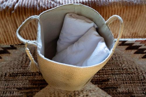a basket with a pillow sitting on a rug at RíoBosque Cabañas de lujo frente al rio desayuno incluido san carlos antioquia in San Carlos