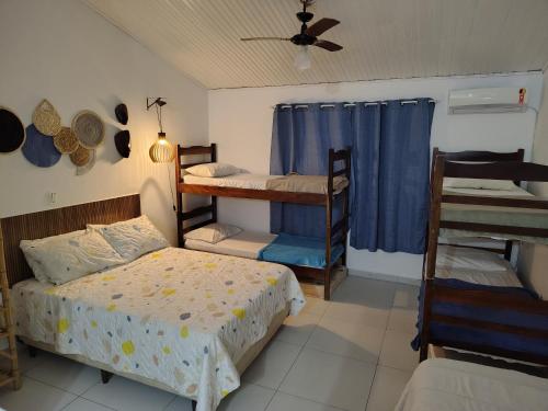 a bedroom with two bunk beds and a ceiling fan at Villa Bali Maresias Lofts in Maresias