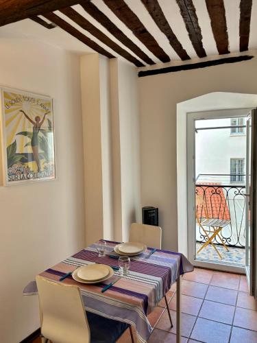 une salle à manger avec une table et des chaises et une fenêtre dans l'établissement Rue Neuve, à Nice