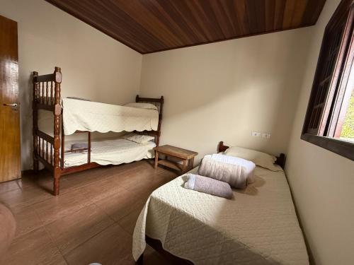 a bedroom with two beds and a crib at Casa para até 8 pessoas ou studio para até 3 com fácil acesso à pontos turísticos in Campos do Jordão