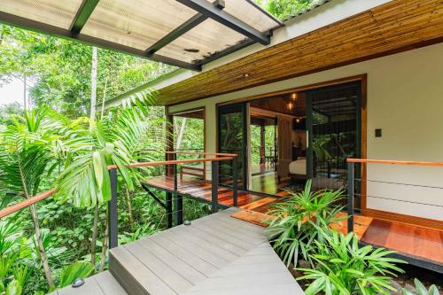 a house in the middle of a forest with a porch at Secret Bungalows Lechu in Chachagua