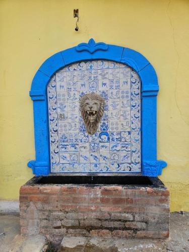 a blue gate with a lion on the side of a building at Casa temporada Vô Panta in Bichinho