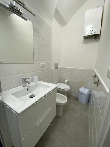 un bagno bianco con lavandino e WC di La Casa di Partenope a Napoli