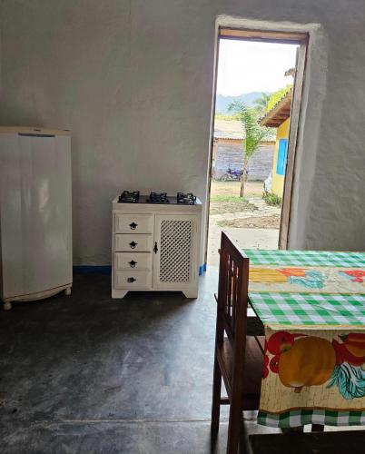 a room with a refrigerator and a table and a window at Casa temporada Vô Panta in Bichinho