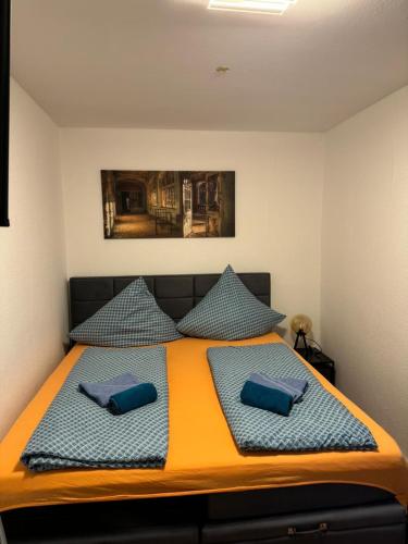a bedroom with a bed with blue pillows at Green Forest in Bad Harzburg