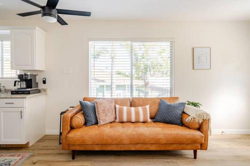 a brown couch in a living room with a ceiling fan at Beacons Beach Cottage in Encinitas