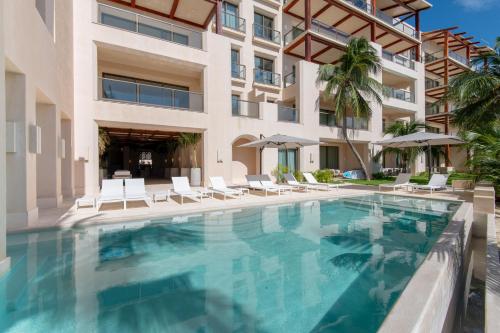 a swimming pool in front of a building at Artila Beach Condos, Isla Mujeres in Isla Mujeres