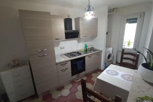 a kitchen with a stove and a table and a window at Tradate centro -150mt dalla stazione Ferrovie Nord in Tradate