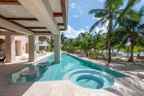 an infinity pool in a villa with palm trees at Artila Beach Condos, Isla Mujeres in Isla Mujeres
