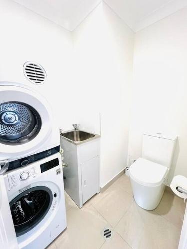 a bathroom with a washing machine and a toilet at Private & Cozy villa for you! in Sutherland
