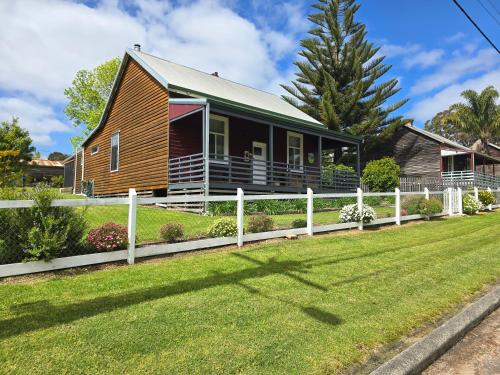 a house with a fence in front of a yard at Millhouse on Pine in Pemberton