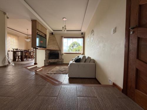 a living room with a couch and a fireplace at Casa para até 8 pessoas ou studio para até 3 com fácil acesso à pontos turísticos in Campos do Jordão