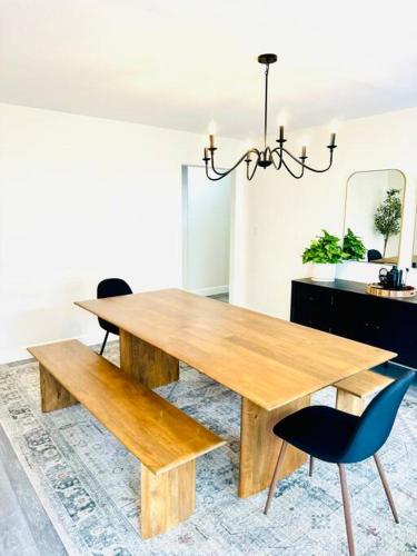 a wooden dining table with two chairs and a mirror at Leucadia's Beach House w Game Room in Encinitas