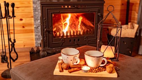 a tray with two cups and cookies in front of a fireplace at Sapanca Ravine Bungalow in Sapanca